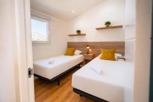 two beds in a small room with a window at Kampaoh El Pedroso in El Pedroso +55 photos
