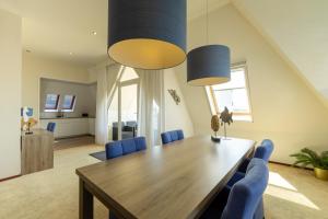 ein Esszimmer mit einem Holztisch und blauen Stühlen in der Unterkunft Strandhotel de Vassy in Egmond aan Zee + 32 Fotos
