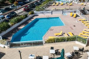 an overhead view of a swimming pool with chairs and tables at Résidence Mer & Golf Sokoburu in Hendaye