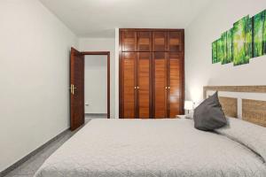 a bedroom with a bed and a wooden door at NG CANDELARIA - Tenerife in Candelaria
