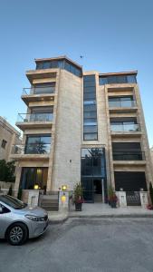 a building with a car parked in front of it at Amman Suites in Amman