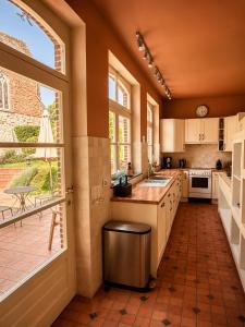 a large kitchen with a counter and a large window at Villa Theresa à 25 min de PAIRI DAIZA in Soignies