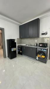 a kitchen with black cabinets and appliances in a room at Amman Suites in Amman