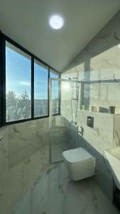 a white bathroom with a toilet and a sink at Amman Suites in Amman +81 photos