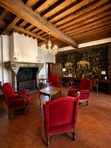a living room with red chairs and a fireplace at Villa Theresa à 25 min de PAIRI DAIZA in Soignies
