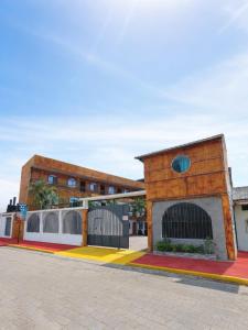 ein Backsteingebäude mit einem Zaun davor in der Unterkunft ECUADOR Hotel Pedernales MrRobert in Pedernales