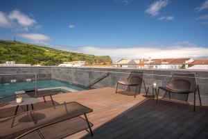 a deck with two chairs and a swimming pool at The Book Hotel in Horta