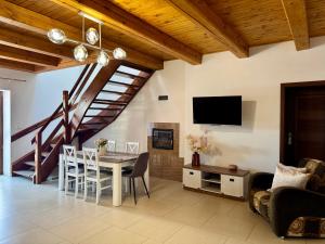 a living room with a dining room table and a tv at Pod skrzydłami IV in Miłomłyn