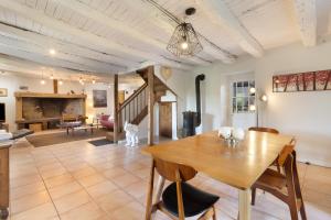 a dining room and living room with a wooden table at Les Temps Des Sources in Veyrines-de-Domme