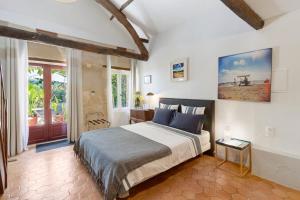 a bedroom with a large bed with blue pillows at Les Temps Des Sources in Veyrines-de-Domme