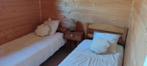 a room with two beds and a night stand with a table at Chalet rocenel in Le Malzieu-Ville