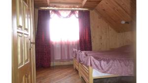 a bedroom with a bed and a window at Садиба Хатинка у Люби in Yaremche
