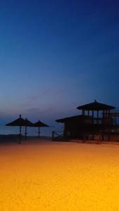 a beach with some umbrellas and the ocean at Apartmani Val in Pula