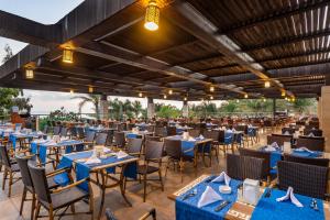 an empty restaurant with blue tables and chairs at Sunis Kumköy Beach Resort Hotel & Spa in Side