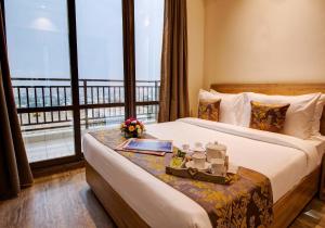 a hotel room with a bed and a balcony at Rhythm Gurugram, Hotel & Suites, Sohna Road, Sector 68 in Gurgaon +74 photos