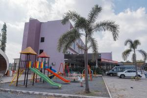 a playground with a slide in front of a building at Hotel Rangoli - 10 min from Palsana chowk in Navsāri