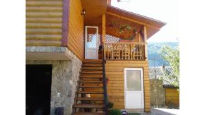 a house with a staircase leading up to a balcony at Садиба Хатинка у Люби in Yaremche