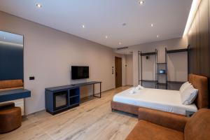 a hotel room with a bed and a tv at Zurich Hotel in Ksamil