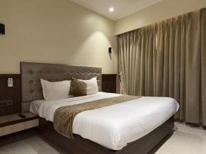 a bedroom with a large bed and a window at Hotel Golden Crown in Mumbai +19 photos