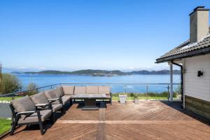 a patio with a couch and chairs on a deck at The Green Bay in Sandnes
