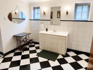 a bathroom with a sink and a black and white checkered floor at Quiet Mountain Country House in Hekpoort +65 photos