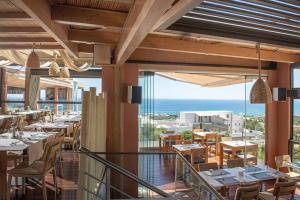 a restaurant with tables and chairs and a view of the ocean at Esperides Resort Crete, The Authentic Experience in Hersonissos
