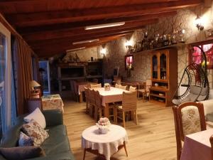 a living room with tables and chairs and a dining room at Guest House Mijić in Korenica
