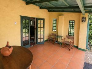 a patio with a table and chairs in a room at Quiet Mountain Country House in Hekpoort