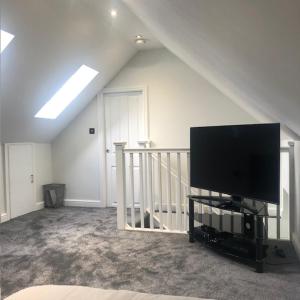 a living room with a flat screen tv and a staircase at Spacious and close to Gatwick in Crawley +7 photos