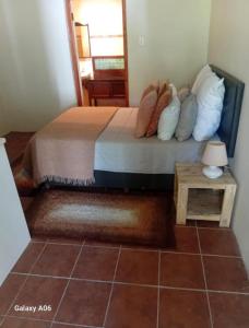 a bedroom with a bed with pillows and a table at Boschberg Accommodation in Somerset East