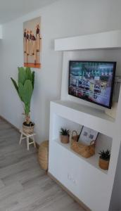 a living room with a tv on a white wall at Lady laying in Le Diamant