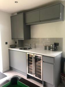 a kitchen with white cabinets and a sink at Spacious and close to Gatwick in Crawley