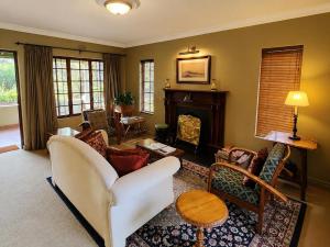 a living room with a white couch and a fireplace at Quiet Mountain Country House in Hekpoort