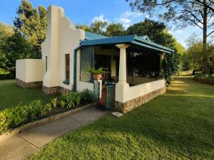 a small white house with a blue roof at Quiet Mountain Country House in Hekpoort