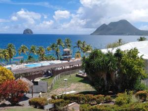 a resort with a swimming pool and a view of the ocean at Lady laying in Le Diamant