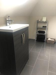 a bathroom with a sink and a tiled floor at Spacious and close to Gatwick in Crawley