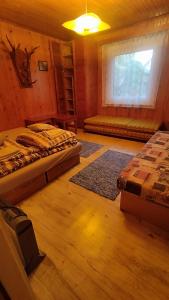 a room with two beds and a window in it at Chatka in Partizánska ľupča