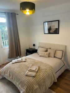 a bedroom with a large bed with two towels on it at Newly Refurbished House in Norwood