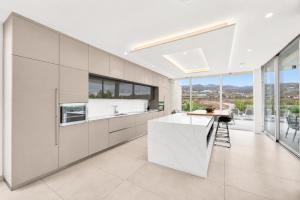 a kitchen with white cabinets and a large window at CHALET 95, Lujo y Piscina Infinity in Adeje