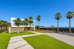 a house with palm trees and a walkway at CHALET 95, Lujo y Piscina Infinity in Adeje