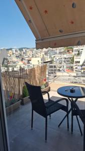 a patio with a table and chairs and a view of a city at The Suite in Kavála