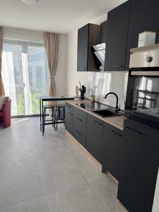eine Küche mit schwarzen Schränken und einem Tisch mit Stühlen in der Unterkunft FlatDeCologne - Sommer in der Stadt- City Apartment Nähe DOM in Köln + 20 Fotos