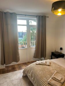 a bedroom with a bed and a large window at Newly Refurbished House in Norwood
