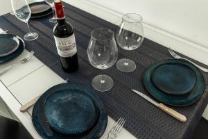a table with plates and glasses and a bottle of wine at Spacious apartment in Talence in Talence