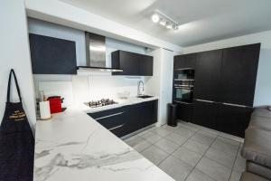 a kitchen with black cabinets and a white counter top at Spacious apartment in Talence in Talence