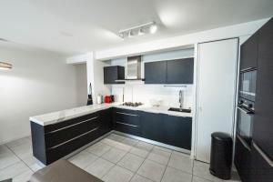 a kitchen with black cabinets and white counter tops at Spacious apartment in Talence in Talence