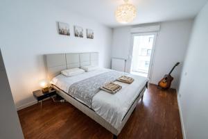 a bedroom with a large bed and a guitar at Spacious apartment in Talence in Talence +15 photos