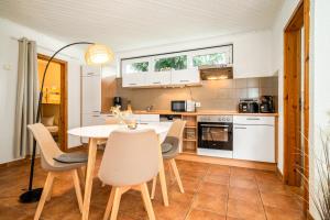 a kitchen with a white table and chairs at Blumenhaus mit Terrasse in Waren