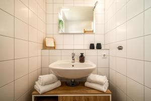a bathroom with a sink and a mirror and towels at Blumenhaus mit Terrasse in Waren +12 photos