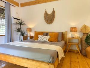 a bedroom with a bed with orange pillows on it at Mandala Tribe Treehouses in Siquijor